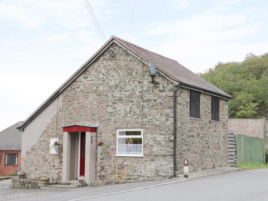 an old stone building with a red door at The Hayloft in Shelve