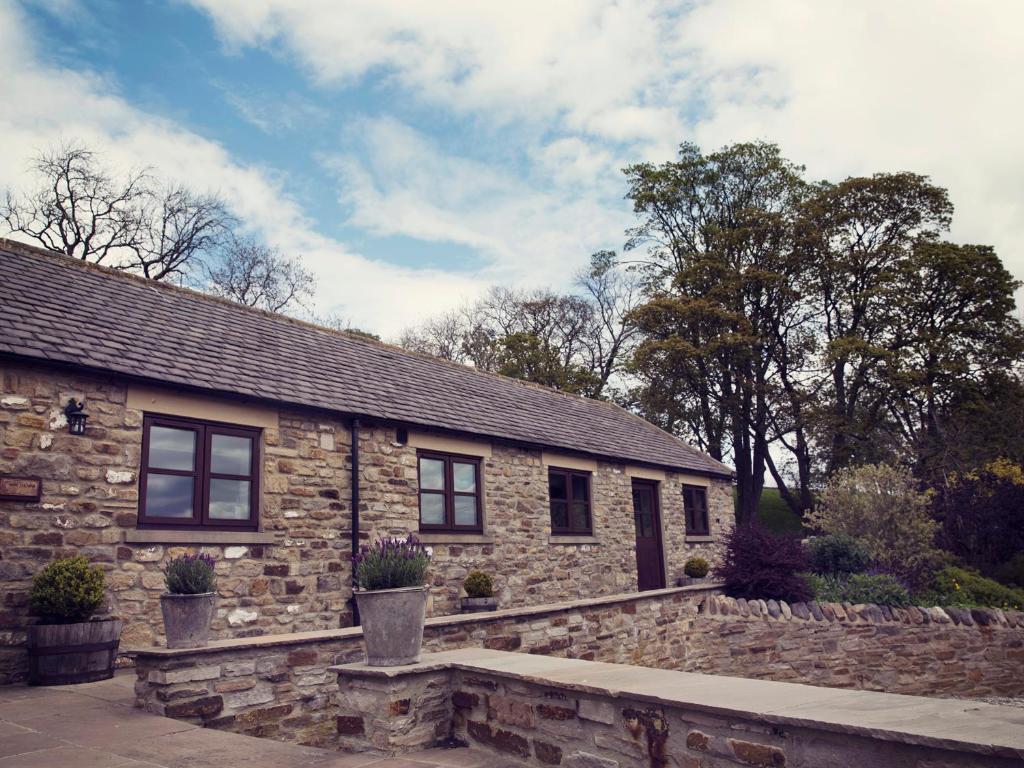 a stone house with a stone wall in front of it at High Thearns in Barnard Castle