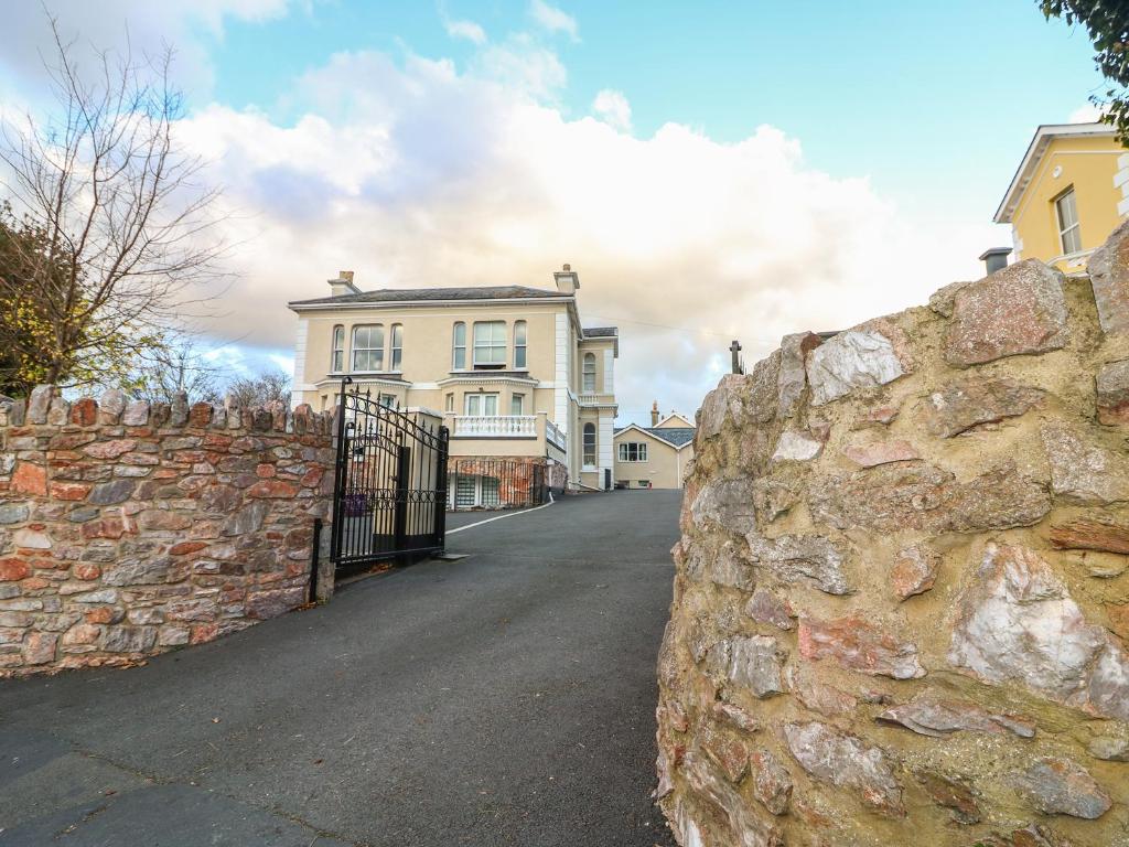 a stone wall in front of a house at Cottage 1 Newcourt in Torquay