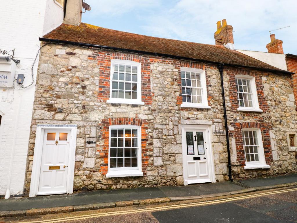 an old stone house with white doors on a street at Tovah in Yarmouth