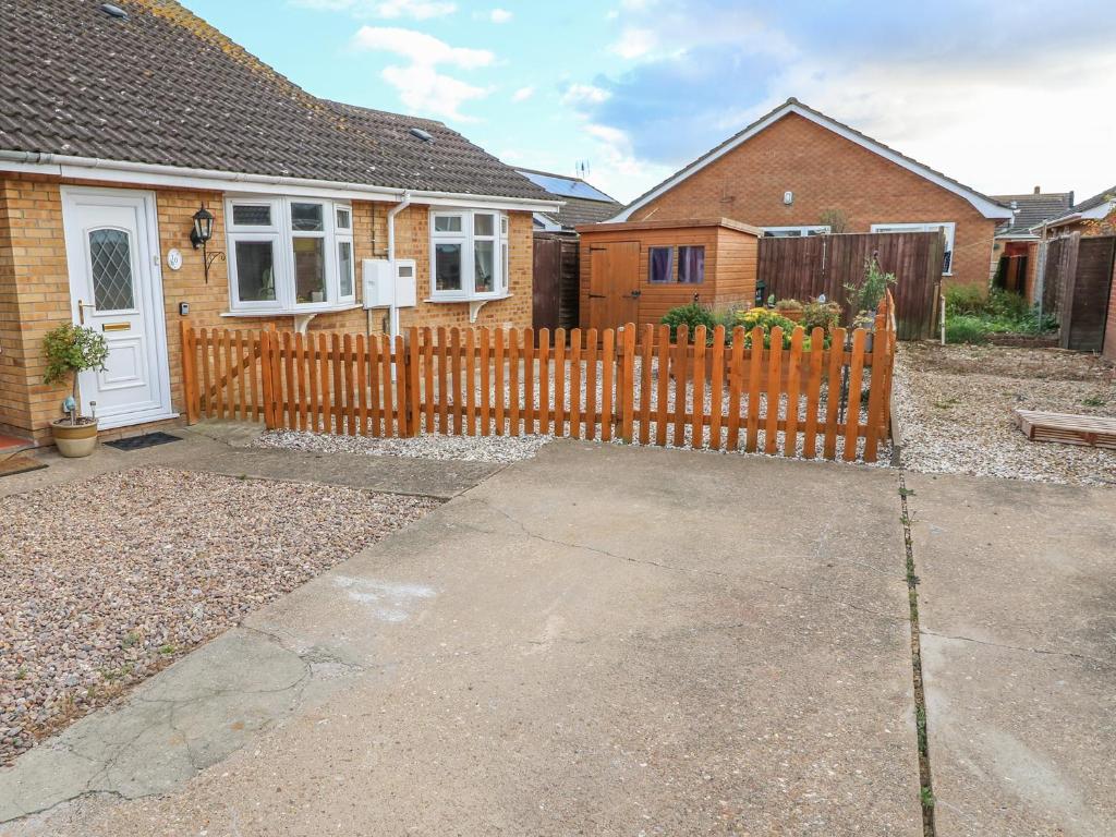a wooden fence in front of a house at Bumble Bee Cottage in Skegness