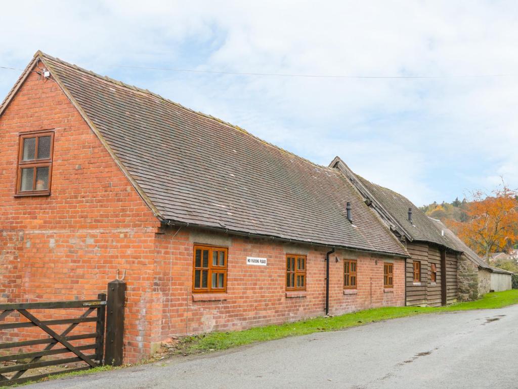 a red brick building with a black roof at Old Hall Barn 4 in Church Stretton