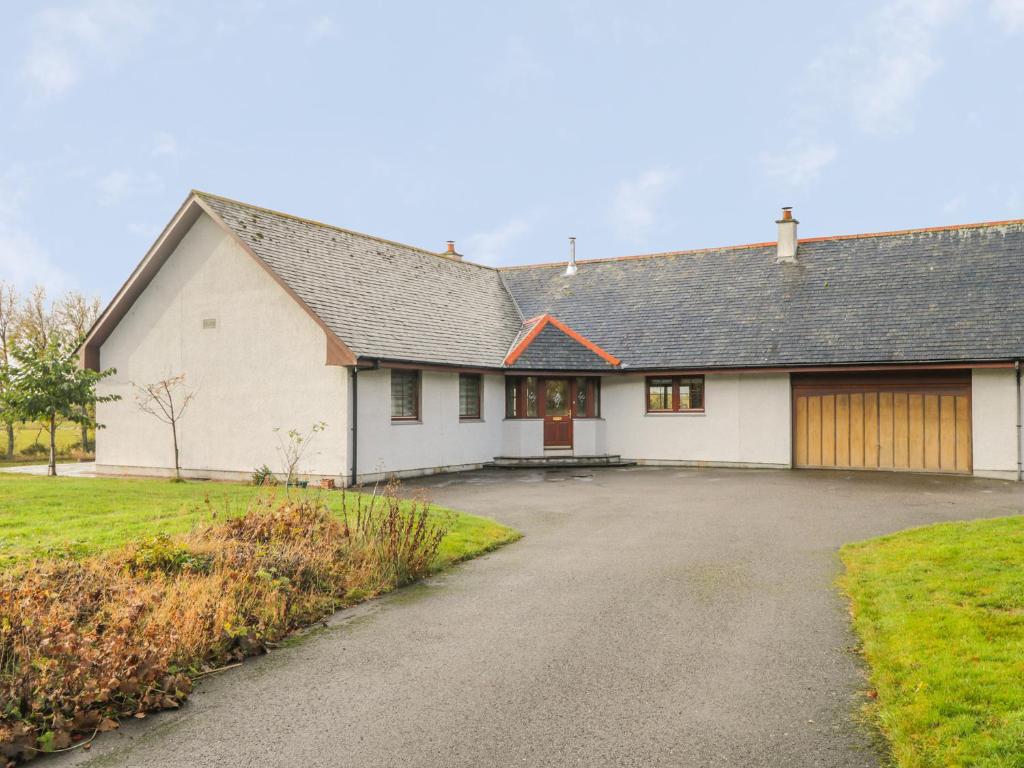 a white house with a driveway in front of it at The Glebe in Invergordon