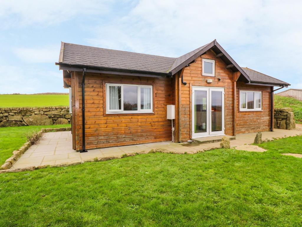 een klein houten huis in een veld bij Borah Lodge in Penzance