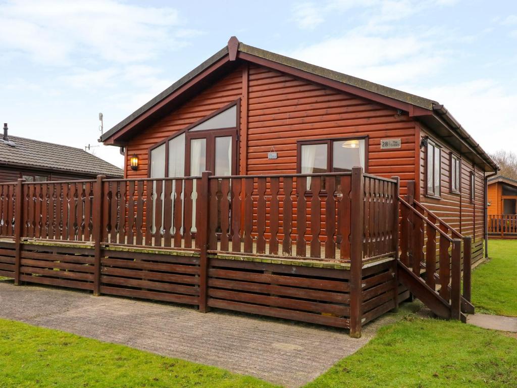 a wooden cabin with a wooden fence at The Cedars in Carnforth