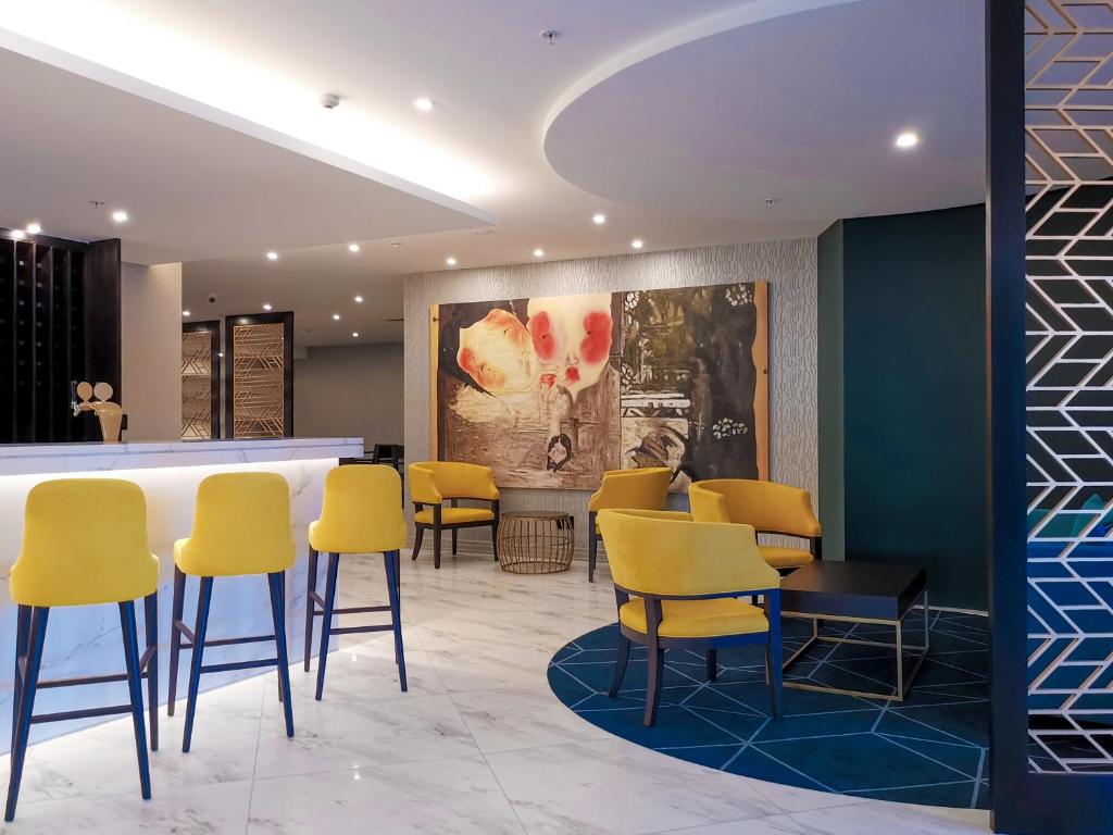 a waiting room with yellow chairs and a counter at Swiss-Belboutique Napier in Napier