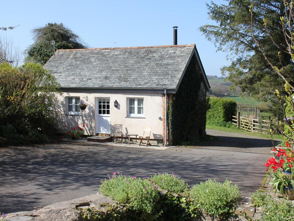 ein weißes Cottage mit einem Tisch und Stühlen davor in der Unterkunft The Linney in Bideford