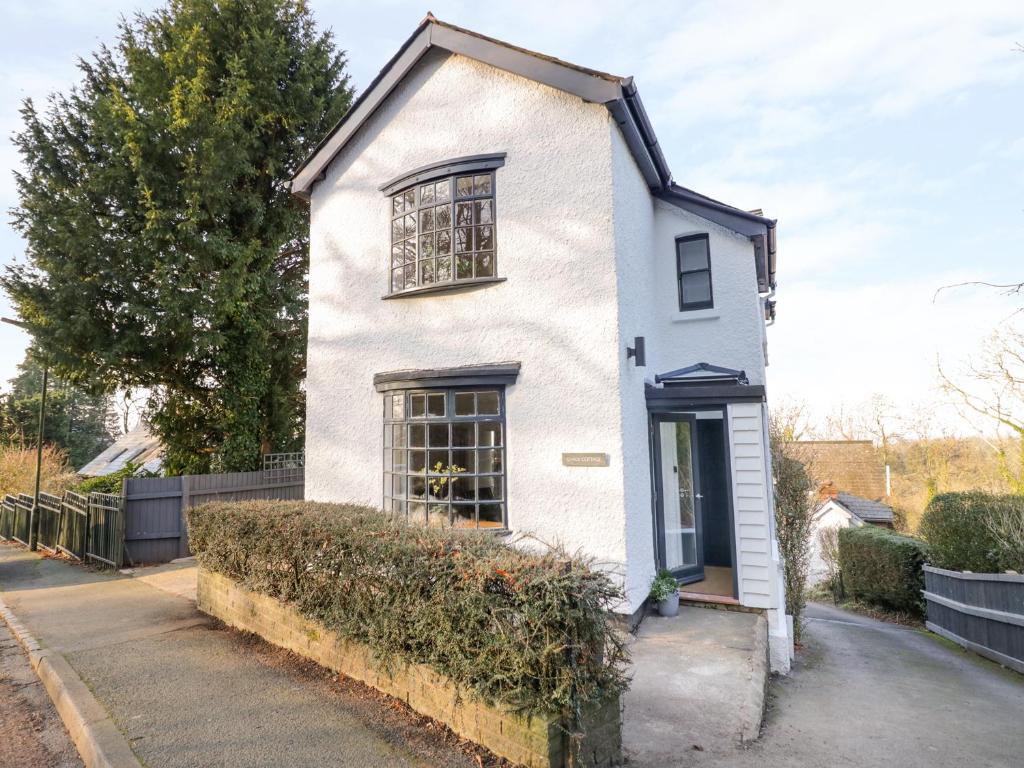 a white house on the side of a street at Chalk Cottage in Great Malvern