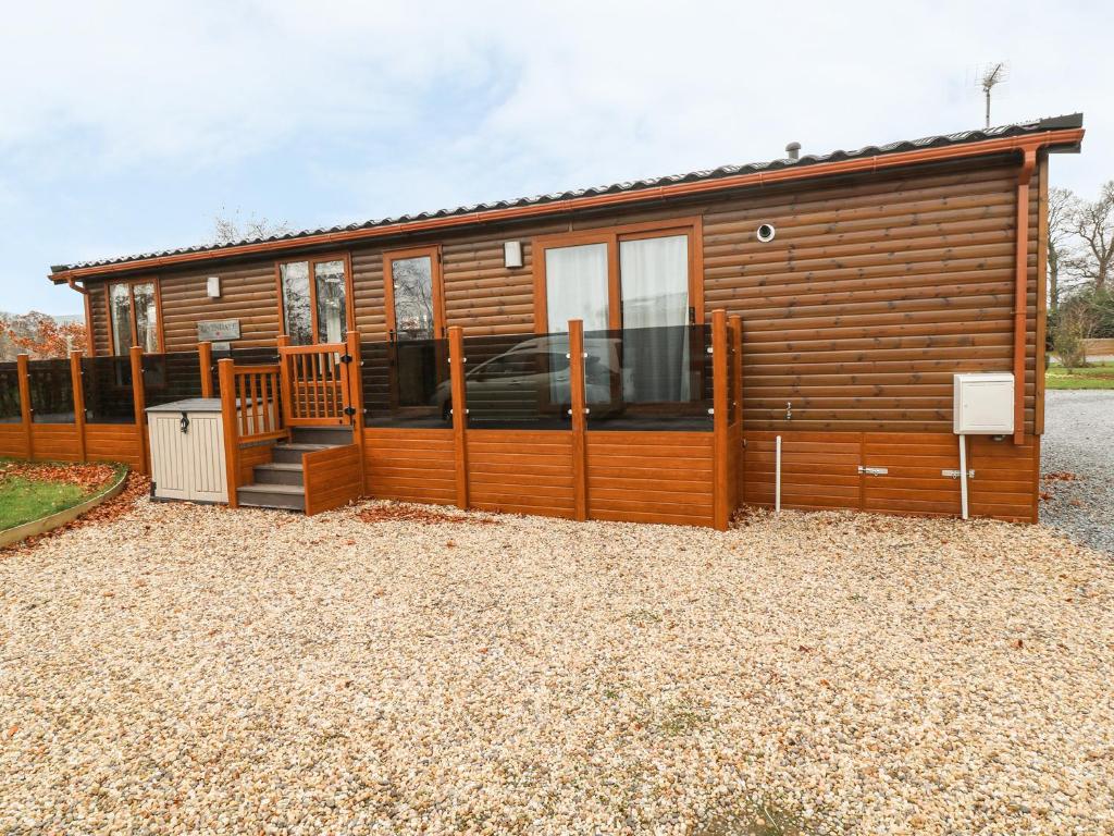 a log cabin with a porch and a fence at Avonal Lodge 24 in Perth