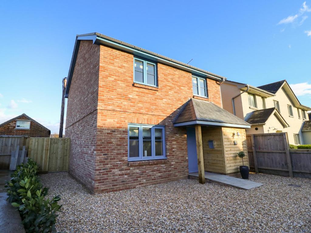 ein Backsteinhaus auf einer Kiesauffahrt in der Unterkunft Crab Cottage in Bembridge