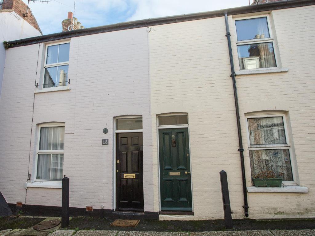a white house with black doors and windows at Wey Cottage in Weymouth