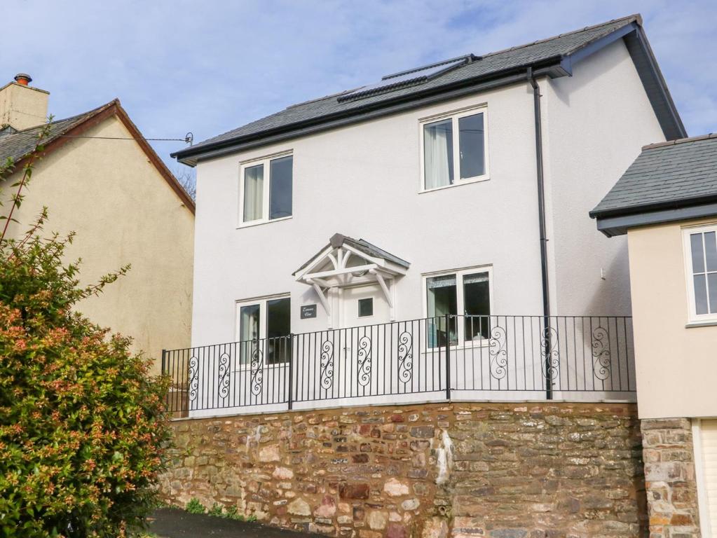 a white house with a black fence at Exmoor View in South Molton