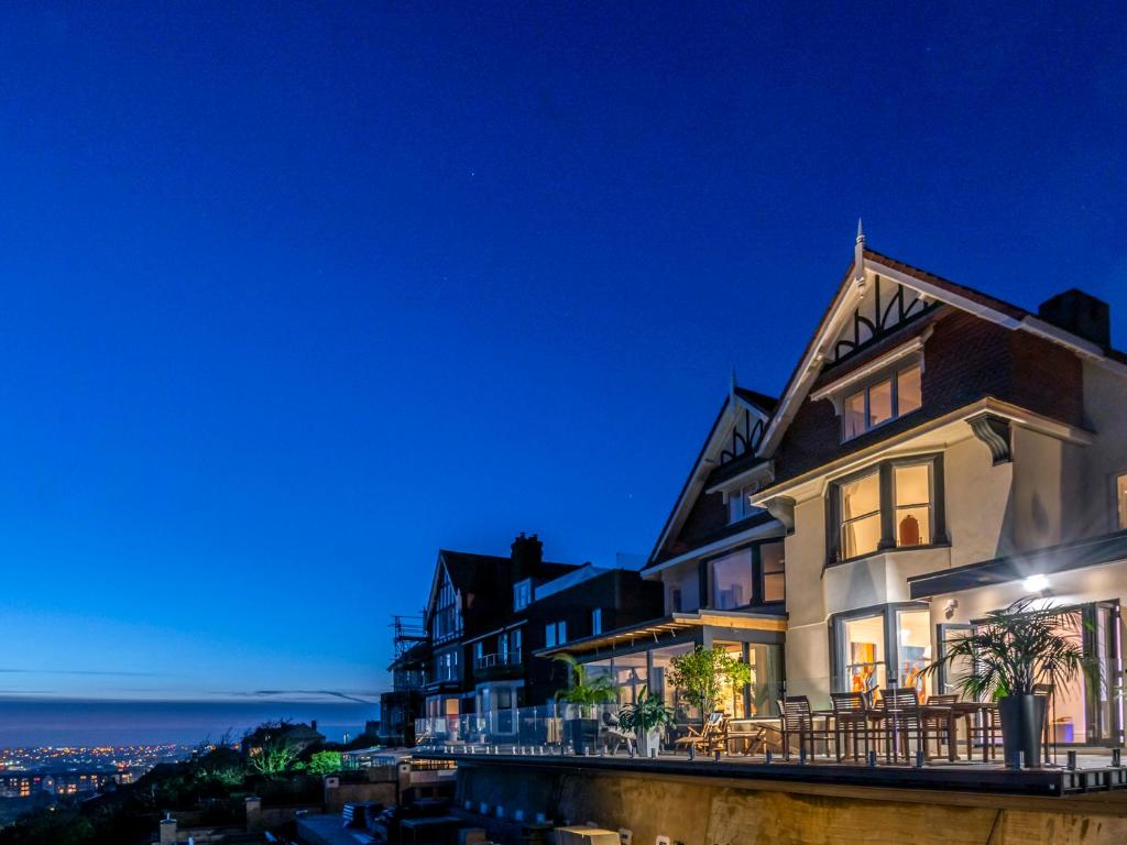 a house with a view of the ocean at night at Cliffhanger in Hollington