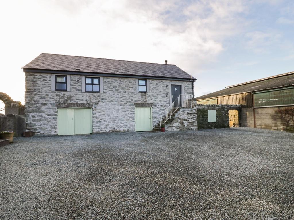 a stone house with two garage doors on a driveway at The Granary in Holyhead