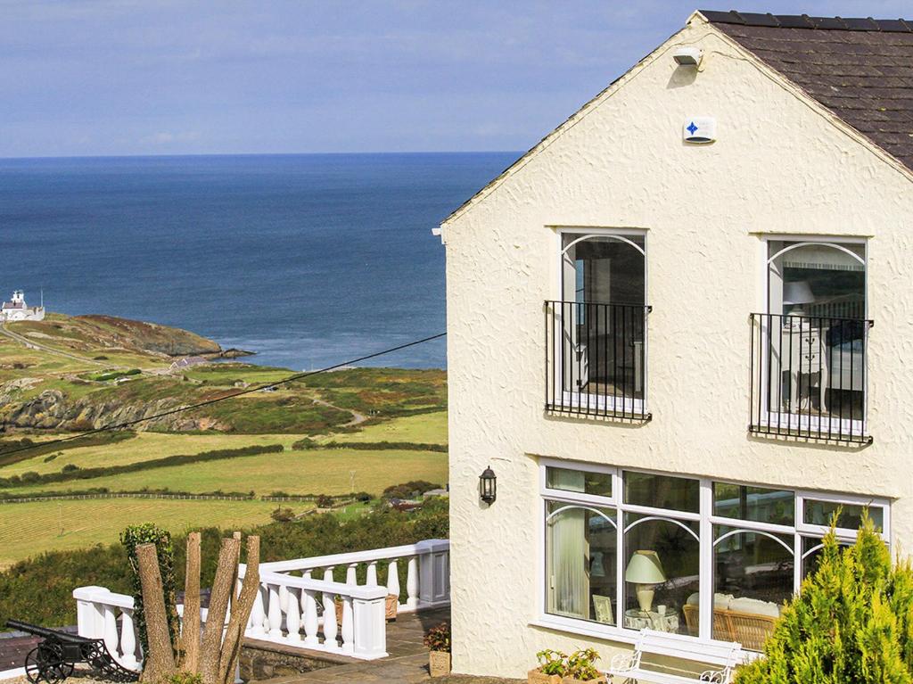 a white house with a view of the ocean at Amolca in Amlwch