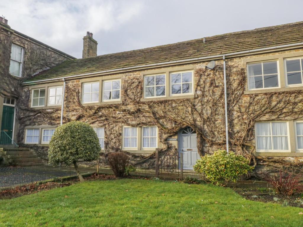 an old stone house with white windows at Grange House in Skipton