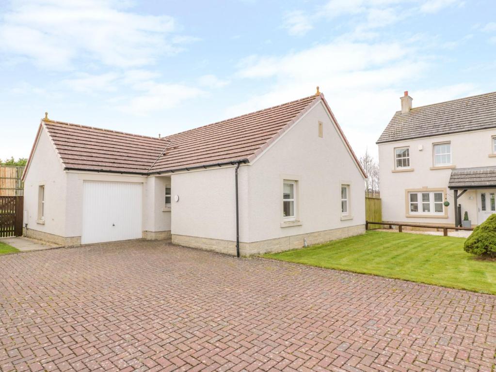 a large white house with a driveway at Bright and Beautiful in Ayr