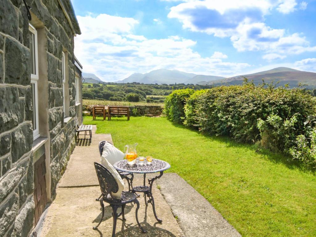 a table and chairs on the patio of a house at Coed Bolyn Lodge in Llanddeiniolen