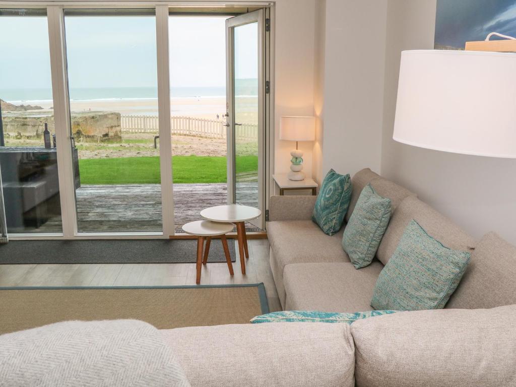 a living room with a couch and a view of the beach at Chapel Rock View, The Dunes in Perranporth