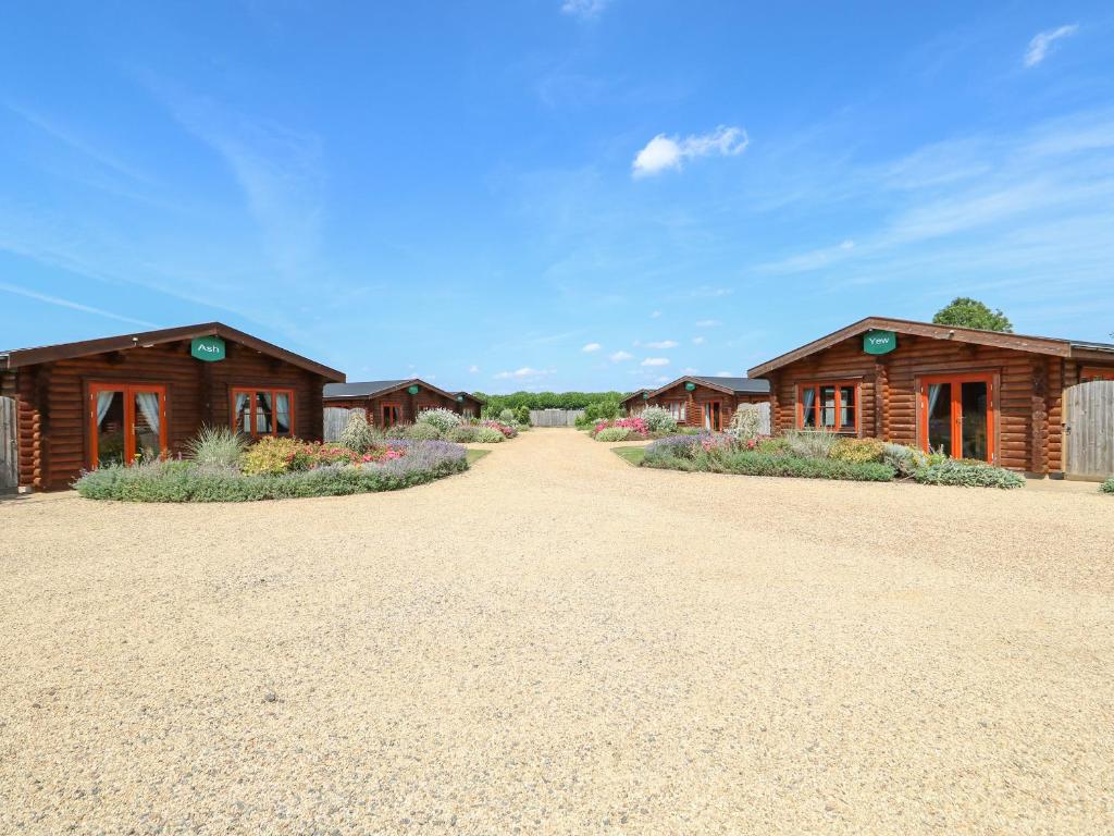 una fila de edificios de madera en un camino de tierra en Willow Lodge en Oakham