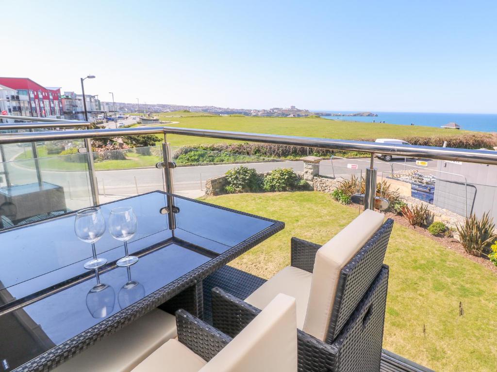 a balcony with a table with wine glasses on it at Ocean Seven in Newquay
