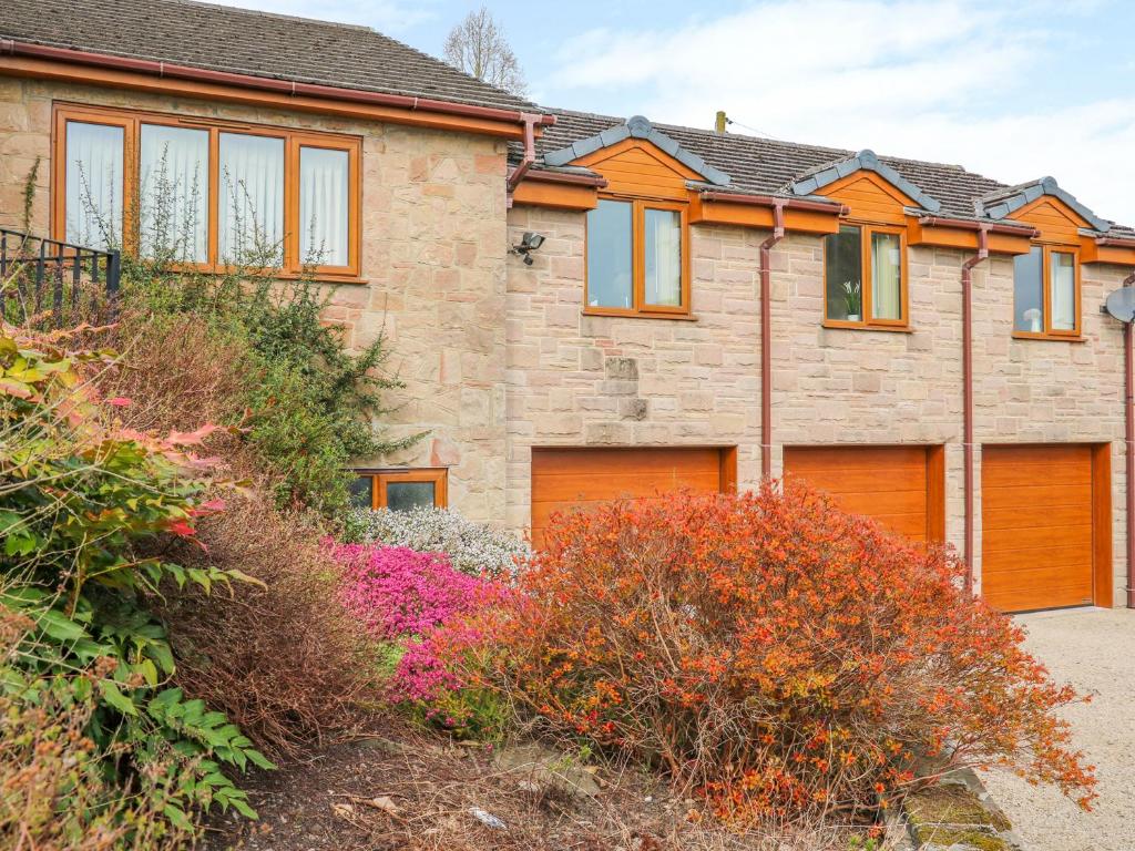 a house with orange garage doors and flowers at Stonecroft Lodge in Belper
