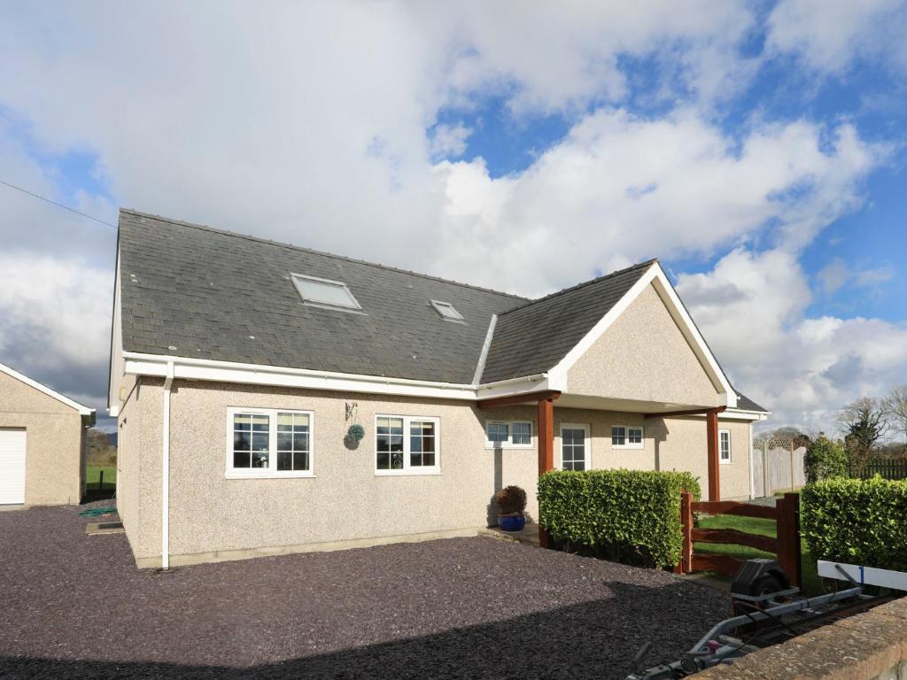 una casa blanca con techo negro en Dwyros, en Pwllheli