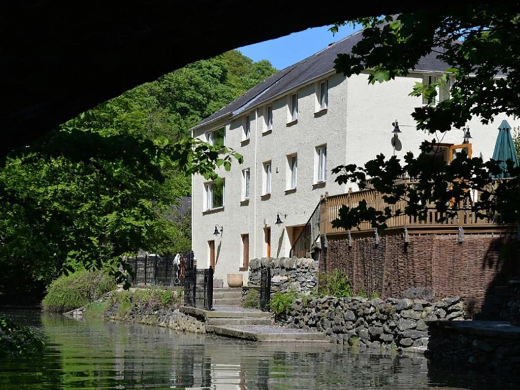 a building sitting next to a body of water at Melin y Coed in Menai Bridge