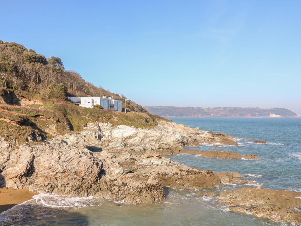 a house on a cliff next to the ocean at The Old Signal House in Torpoint