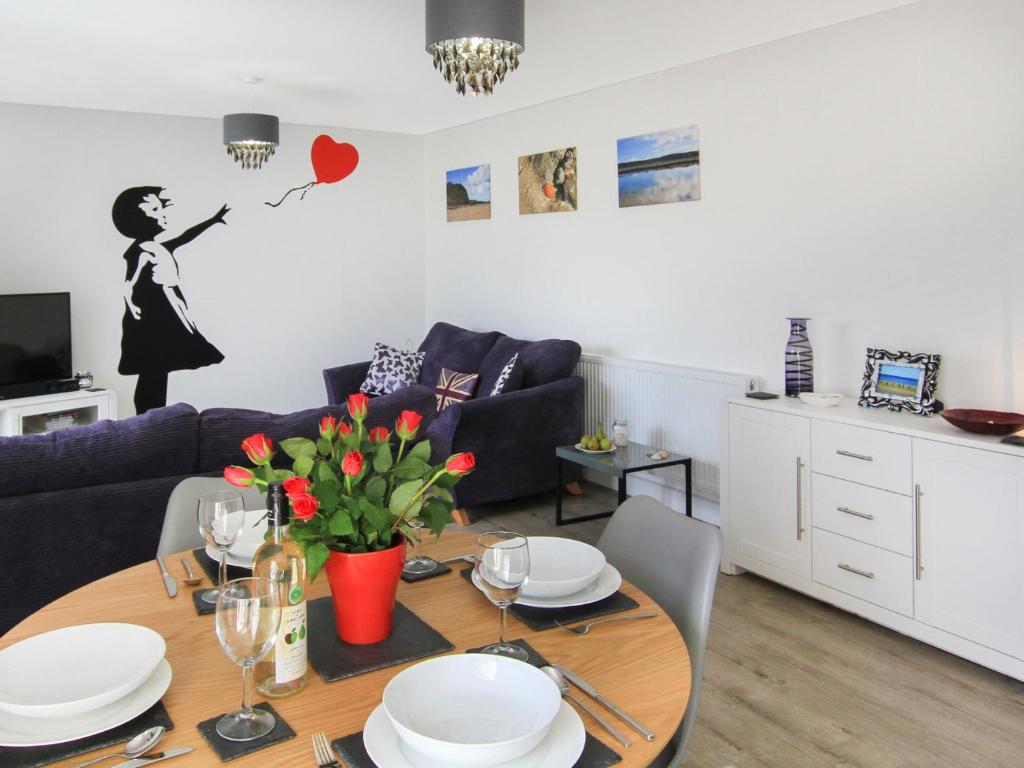 a living room with a table and a couch at Cysgod Y Capel in Benllech