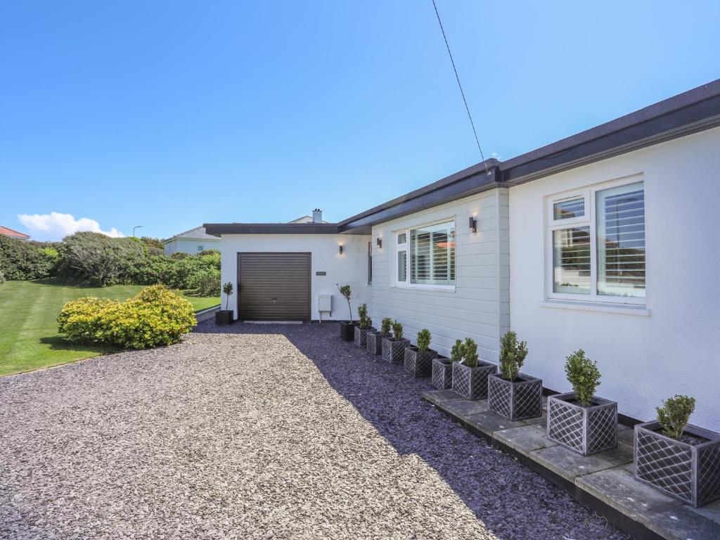 a white house with a driveway at Gadlys in Trearddur