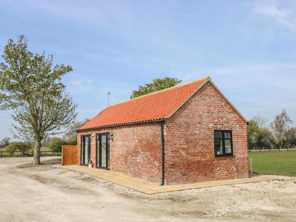a small brick building with an orange roof at Derwent House Farm in Malton