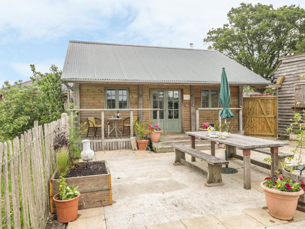 une maison avec une table de pique-nique et une clôture dans l'établissement Little Willow, à Blandford Forum