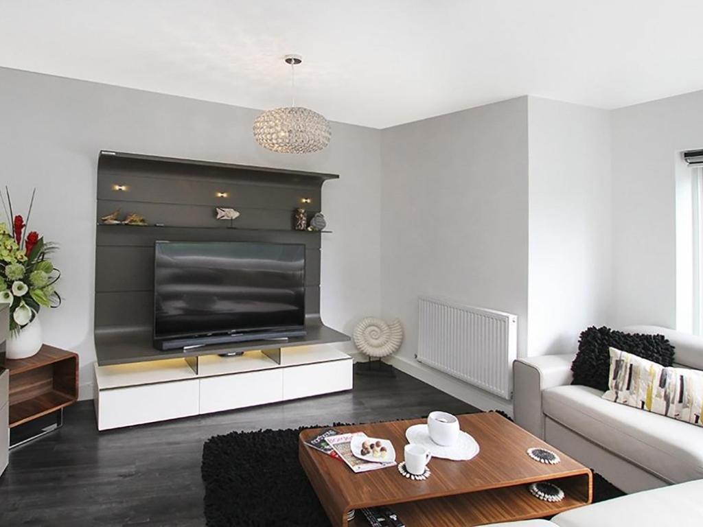 a living room with a large flat screen tv at Quayside in Y Felinheli