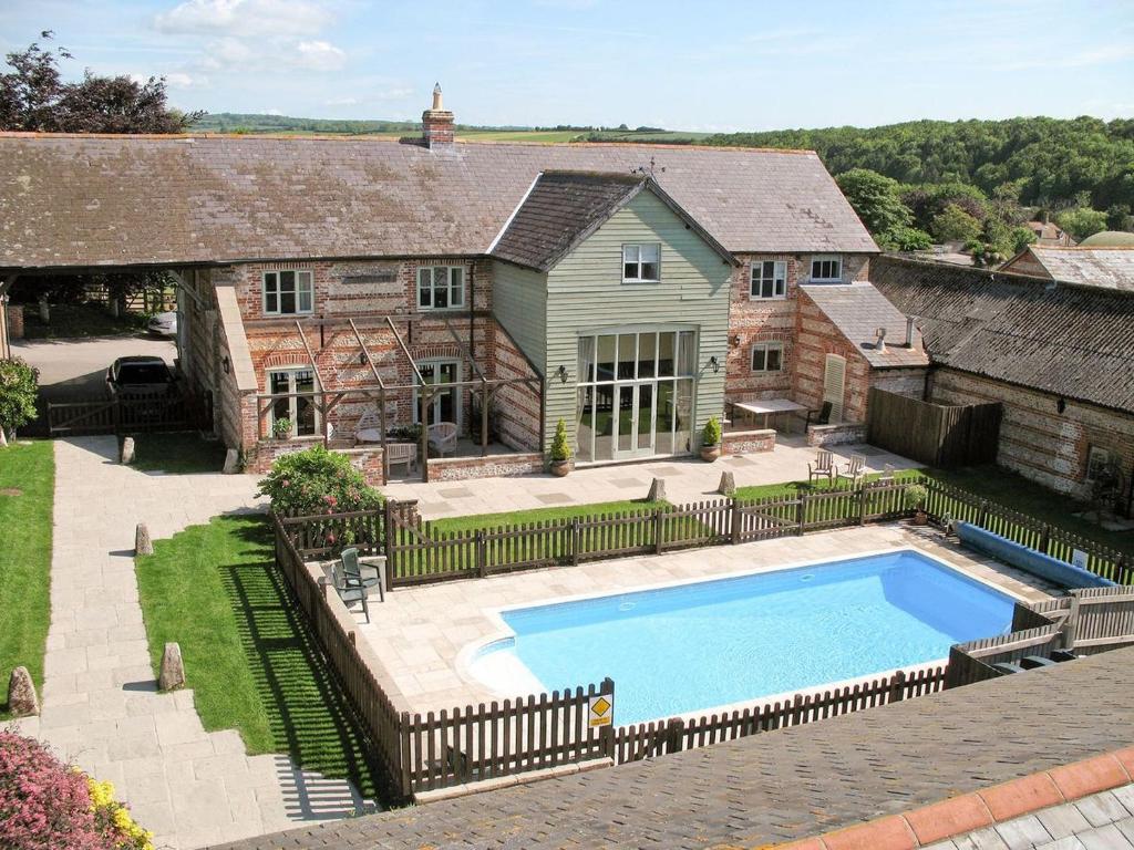 a house with a swimming pool in the yard at Manor Farm Barn in Dorchester