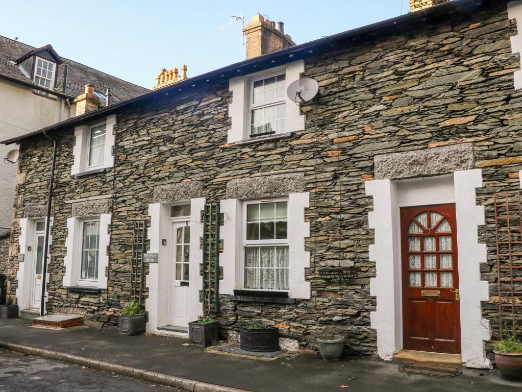 an old stone house with a red door at Old Codgers Cottage in Windermere
