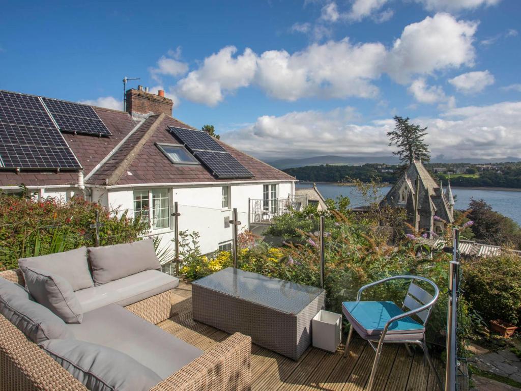 a patio with a couch and a chair on a deck at Rhianfa Cottage in Menai Bridge