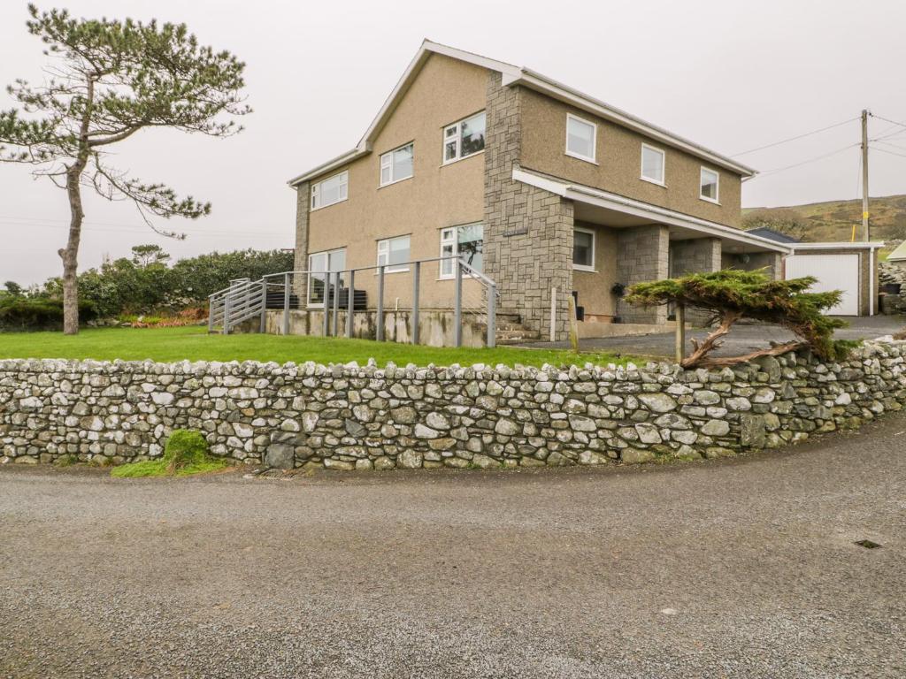 a stone retaining wall in front of a house at Hendre Wylan in Barmouth
