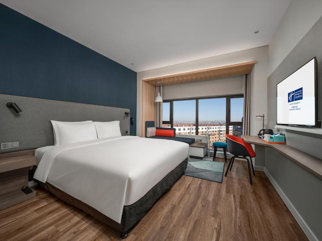 ein Hotelzimmer mit einem Bett und einem Schreibtisch in der Unterkunft Holiday Inn Express Changchun Jingyue, an IHG Hotel in Changchun