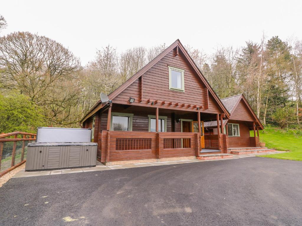 a large wooden house with a hot tub at Pines Pitch in Knighton