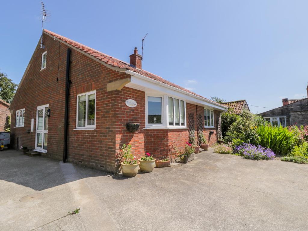 a brick house with potted plants in front of it at Runswick in York