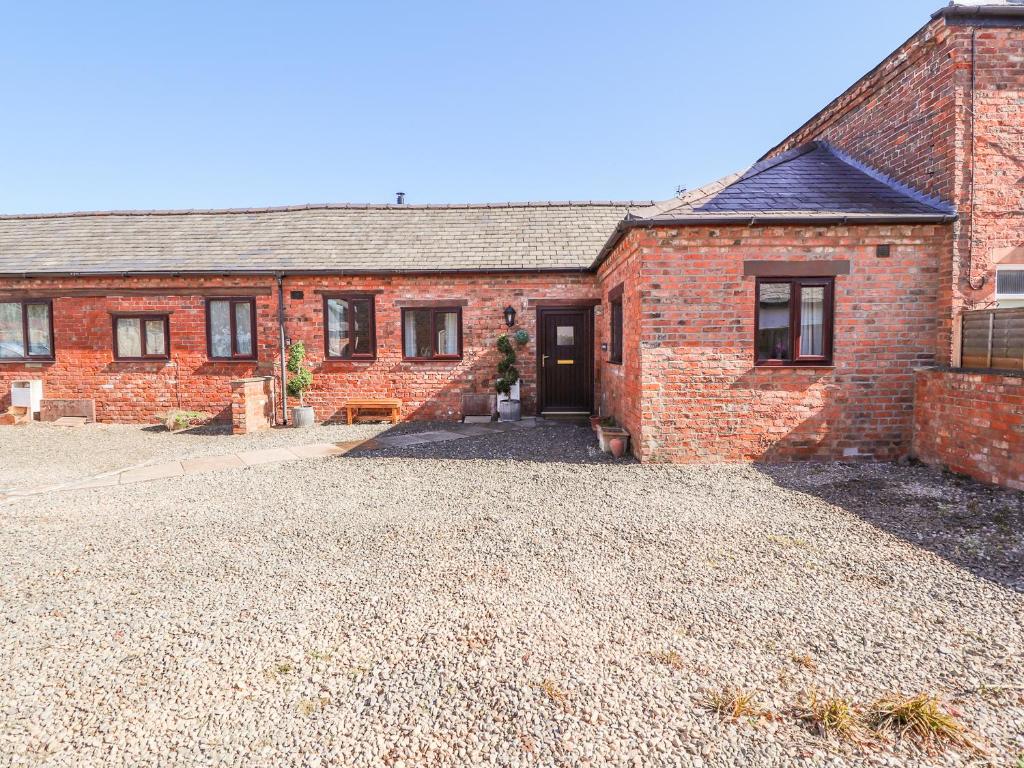 a brick house with a driveway in front of it at Clwyd Cottage in St Asaph