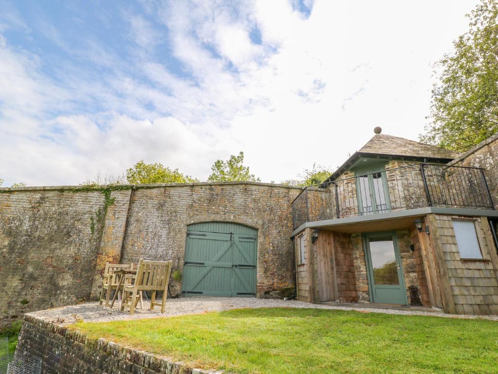 an exterior view of a brick building with a green garage at The Bothy in Callington