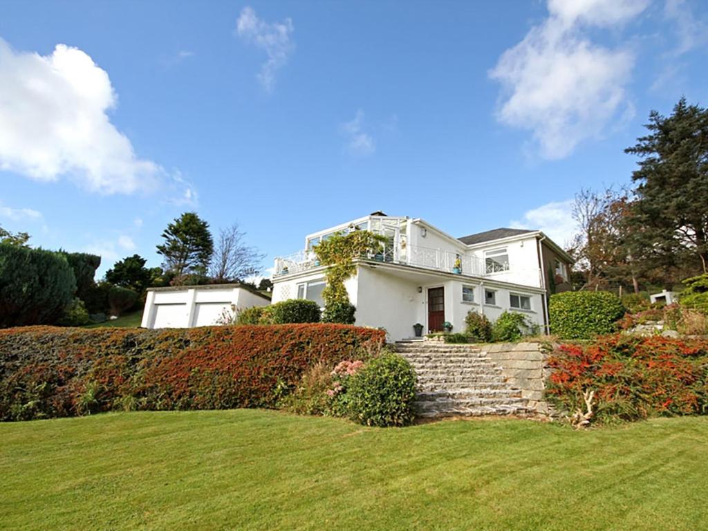 a white house with a landscaped yard at Swn Y Gwynt in Criccieth