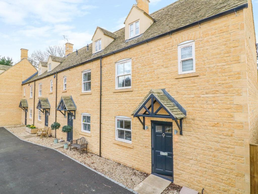a row of brick buildings with a door at Poets Corner in Bourton on the Water