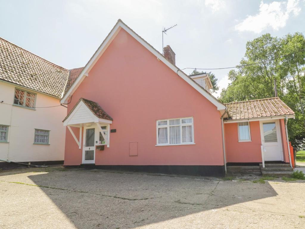 a pink and white house with a driveway at The Bothy in Eye