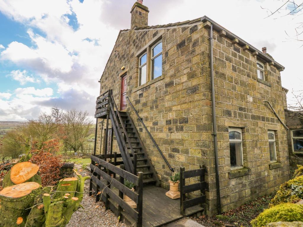 an old brick house with a staircase outside at Highview in Keighley