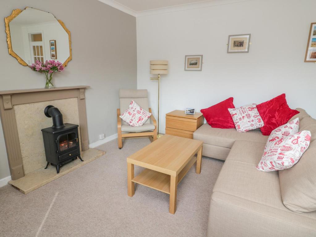 a living room with a couch and a fireplace at The Wynd Apartment in Morpeth