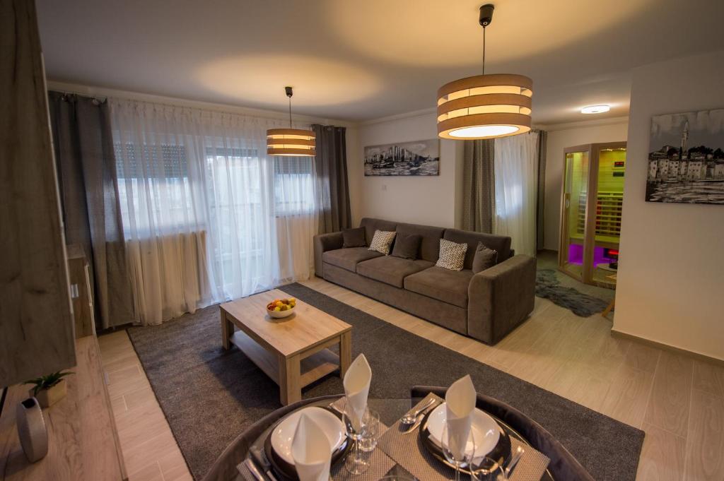 ein Wohnzimmer mit einem Sofa und einem Tisch in der Unterkunft Apartman Lola in Slavonski Brod