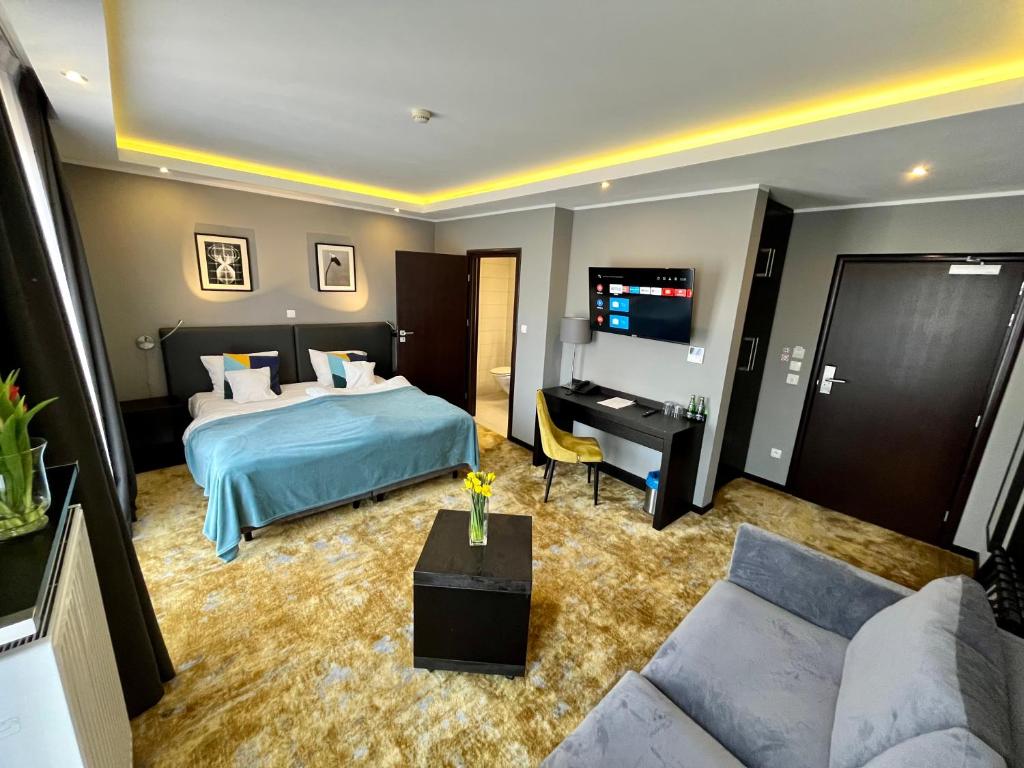 ポズナンにあるMalta Premiumのベッドとテレビが備わるホテルルームです。